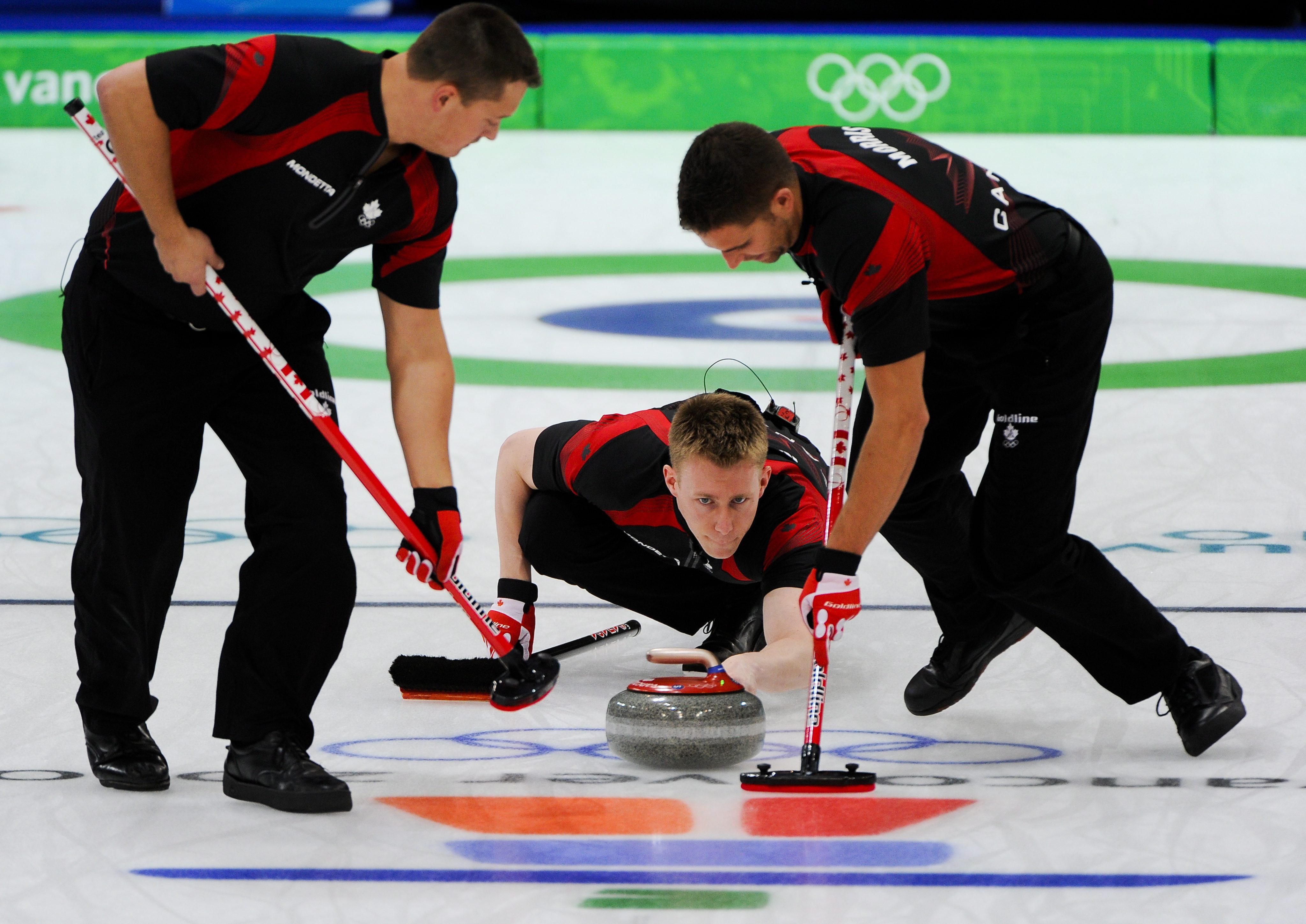 Canada's Mark Kennedy fires a stone between teammates Ben Herbert (B) and John Morris (J) in the Vancouver Winter Olympics men's curling championship final against Norway on February 27, 2010 in Vancouver.  Canada won 6-3 and won a gold medal.  Photo: MTI/EPA/Tannen Maury