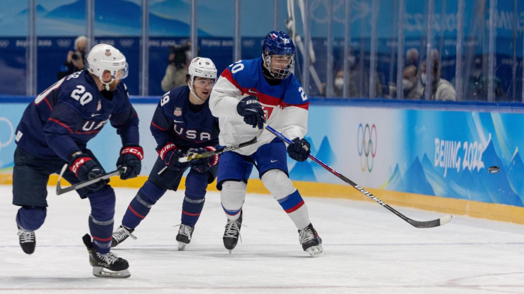 A szlovák Juraj Slafkovsky (j) és az amerikai Steven Kampfer (b) a 2022-es téli olimpia férfi jégkorongtornájának negyeddöntőjében játszott Egyesült Államok - Szlovákia mérkőzésen a pekingi Fedett Stadionban 2022. február 16-án.